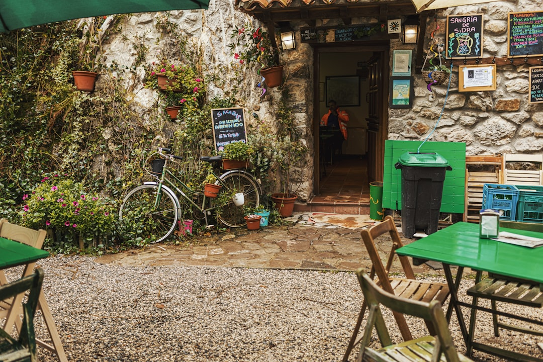 Akşam ışıklandırması altında, sohbet eden müşterilerle dolu hareketli bir kafe içi